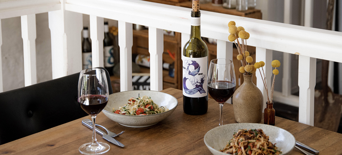 A table with Hither & Yon wine bottle and food